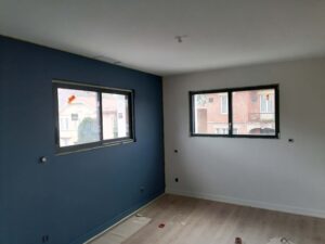 Maison personnalisée Cote Pavée. un pan de mur bleu et un pan de mur blanc. FJréalisation, Maître d'oeuvre en maison individuelle à Labastidette et Bouloc.