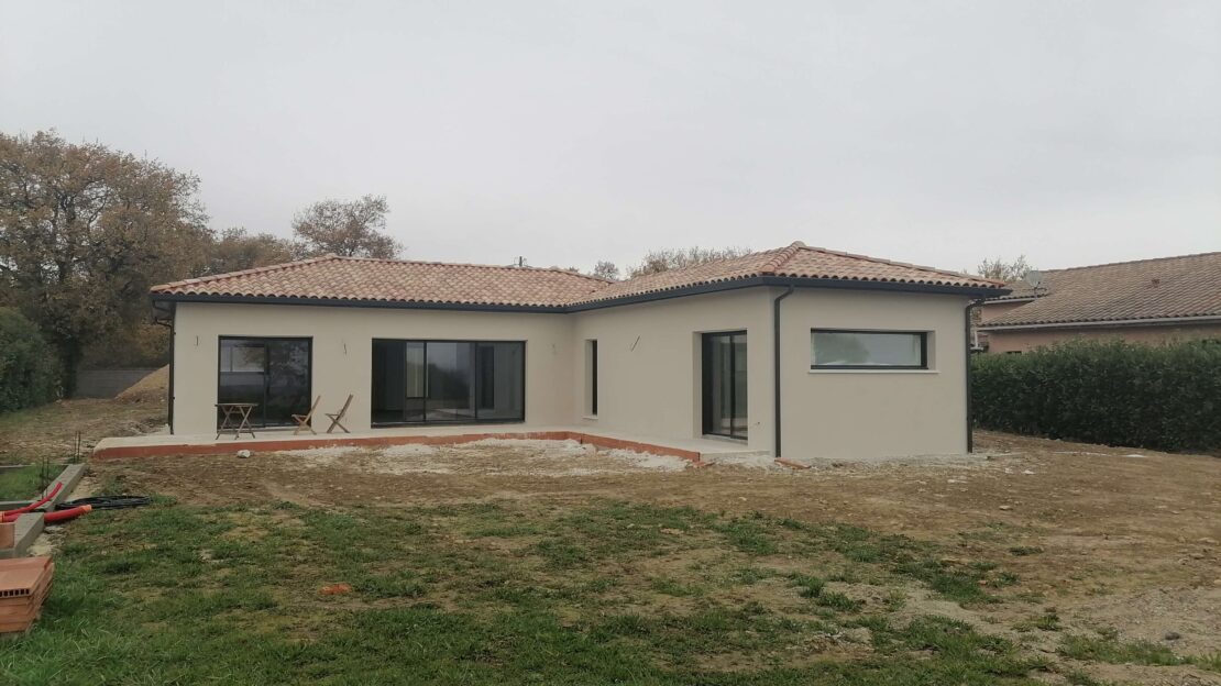 Maison individuelle de plain pied avec plusieurs fenêtre coulissantes donnant sur la terrasse.