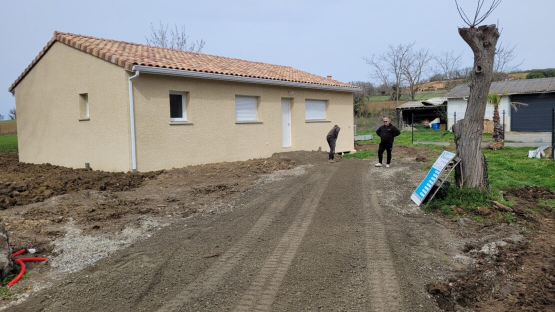 Maison de plain pied avec un enduit de ton jaune clair.