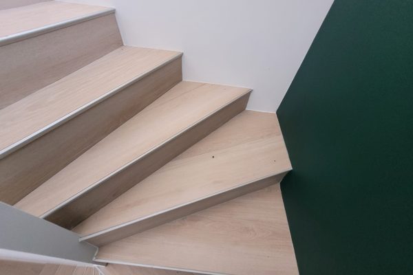 Habillage des marches d'escalier en carrelage imitation parquet.